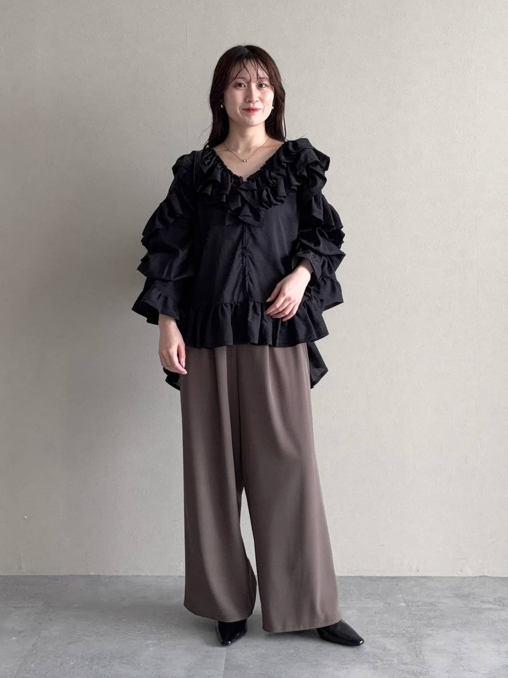 ブラック系のサンダル、ブラック系のシャツ/ブラウス、ベージュ系のパンツドレスを着用したレディースの春コーディネートの1枚目の写真
