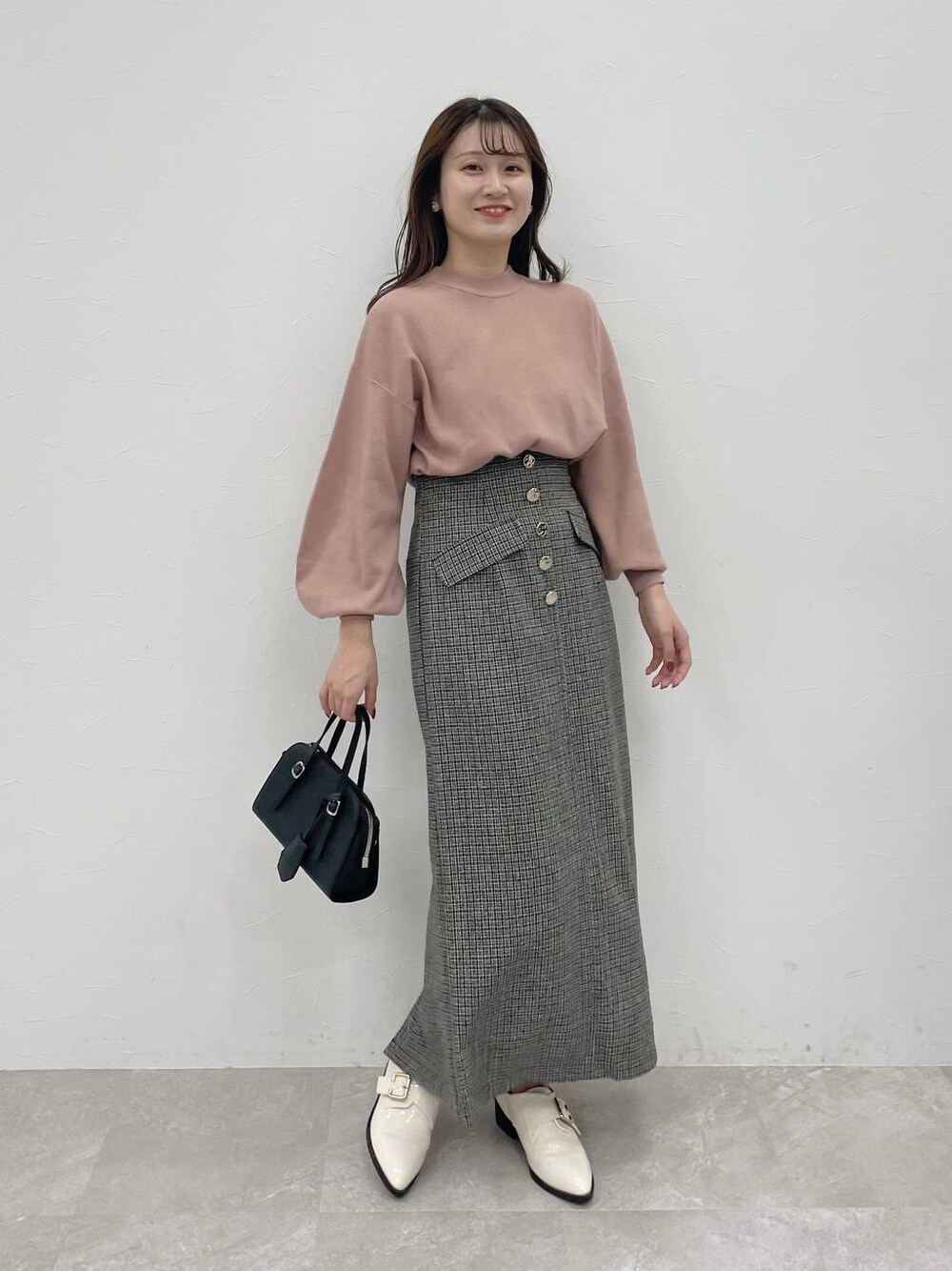 ブラック系のボストンバッグ、ホワイト系のその他シューズ、ピンク系のニット/セーターを着用したレディースの秋コーディネートの1枚目の写真