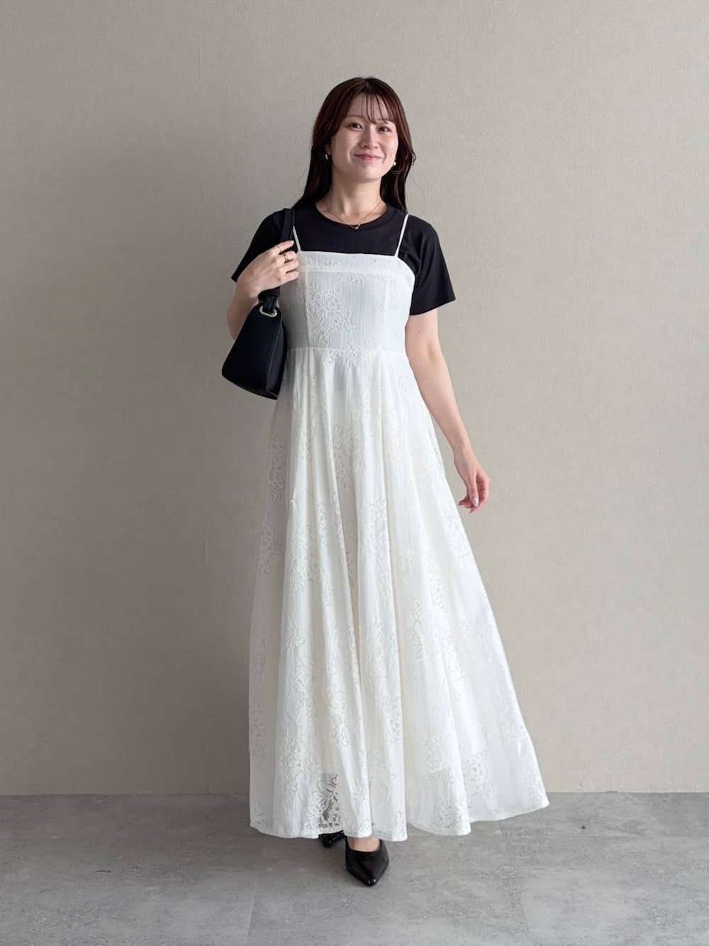 ブラック系のTシャツ/カットソー、ホワイト系のワンピース、ブラック系のサンダルを着用したレディースの夏コーディネートの1枚目の写真