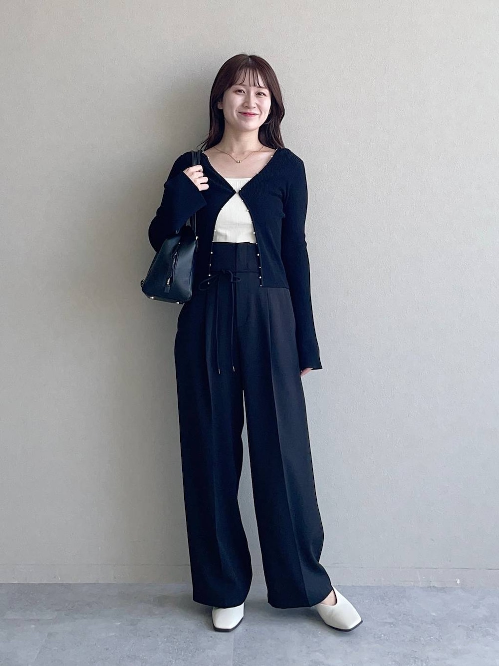 ブラック系のハンドバッグ、ブラック系のその他パンツ、ブラック系のカーディガン/ボレロを着用したレディースの秋コーディネートの1枚目の写真