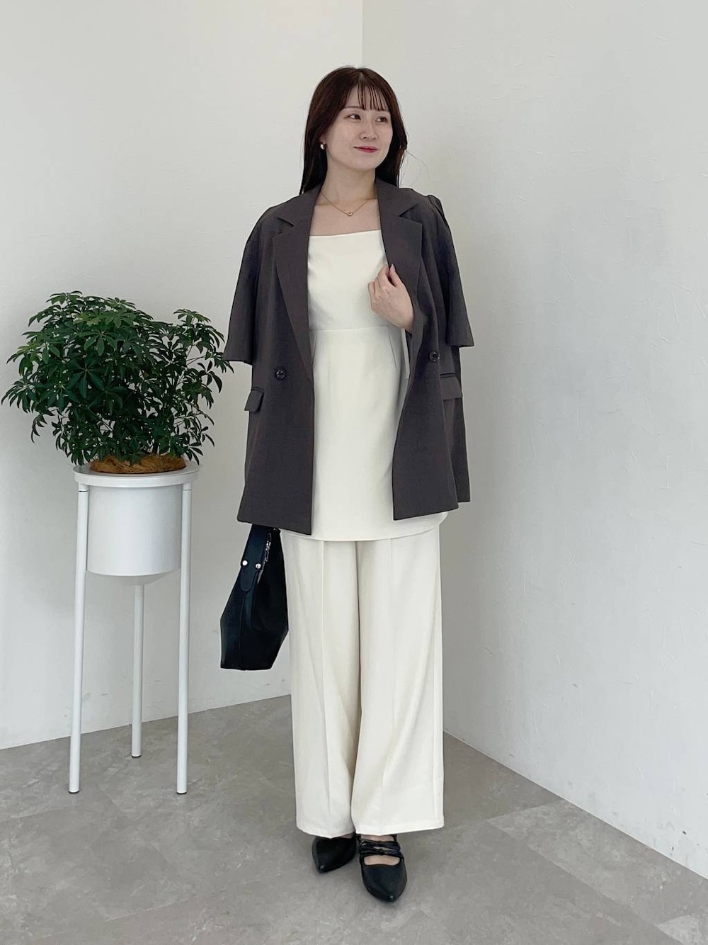 ブラウン系のテーラードジャケット、ブラック系のショルダーバッグ、ブラック系のパンプスを着用したレディースの夏コーディネートの1枚目の写真