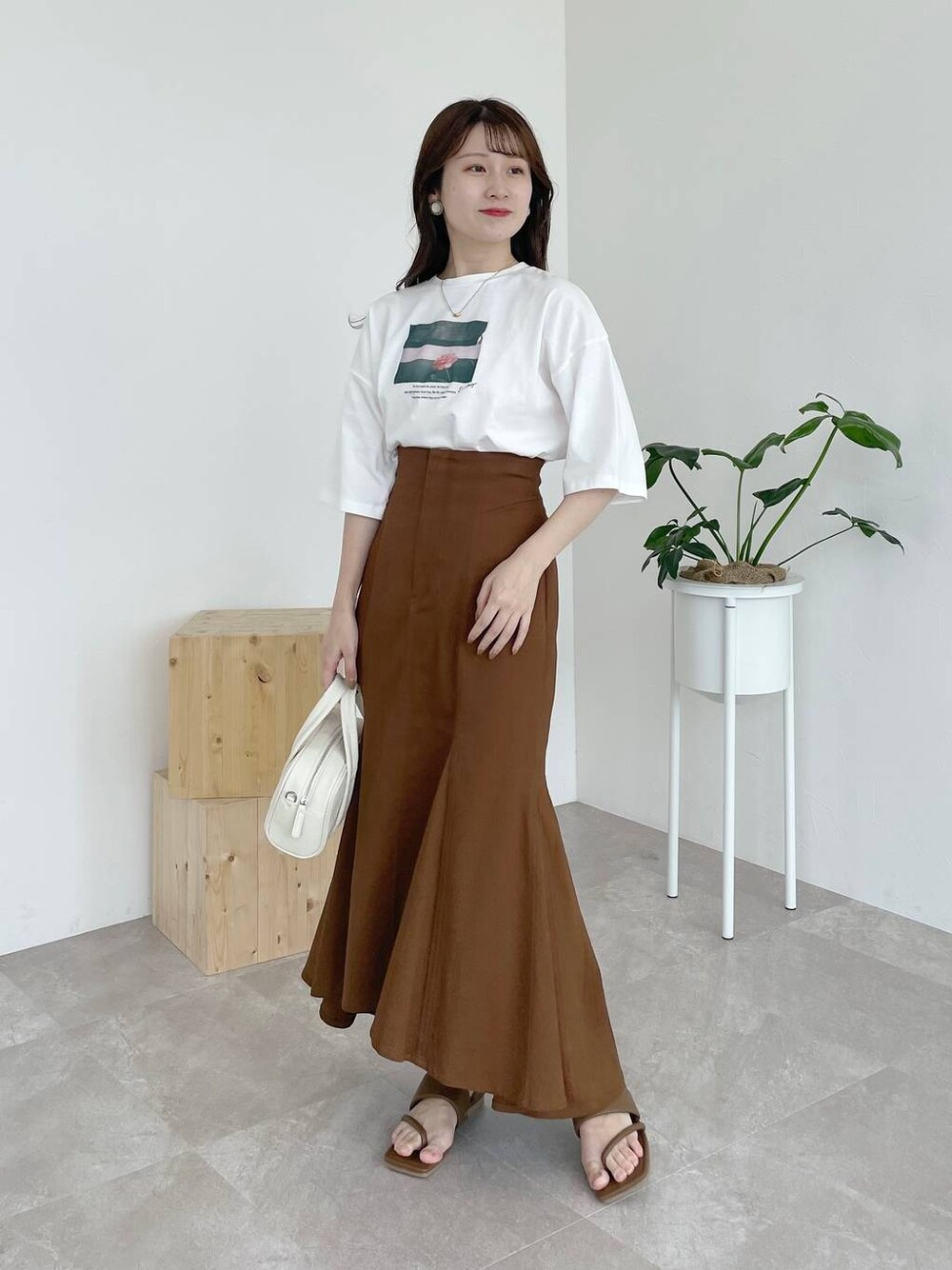 ブラウン系のサンダル、ホワイト系のTシャツ/カットソー、ホワイト系のボストンバッグを着用したレディースの夏コーディネートの1枚目の写真