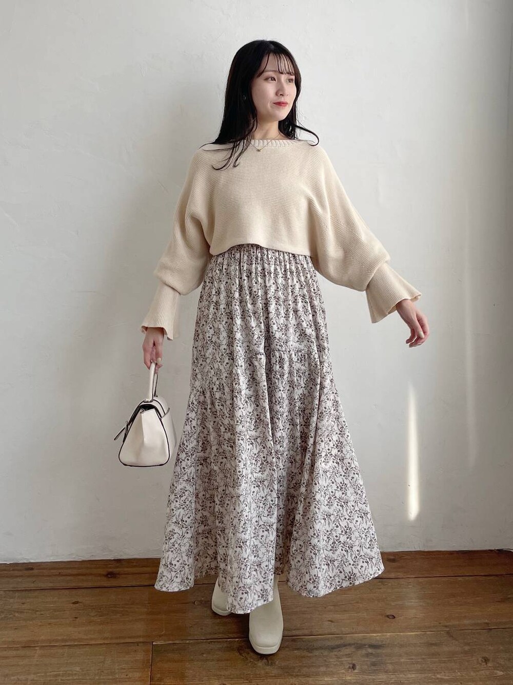 ホワイト系のハンドバッグ、ホワイト系のブーツ、ホワイト系のワンピースを着用したレディースの秋コーディネートの1枚目の写真