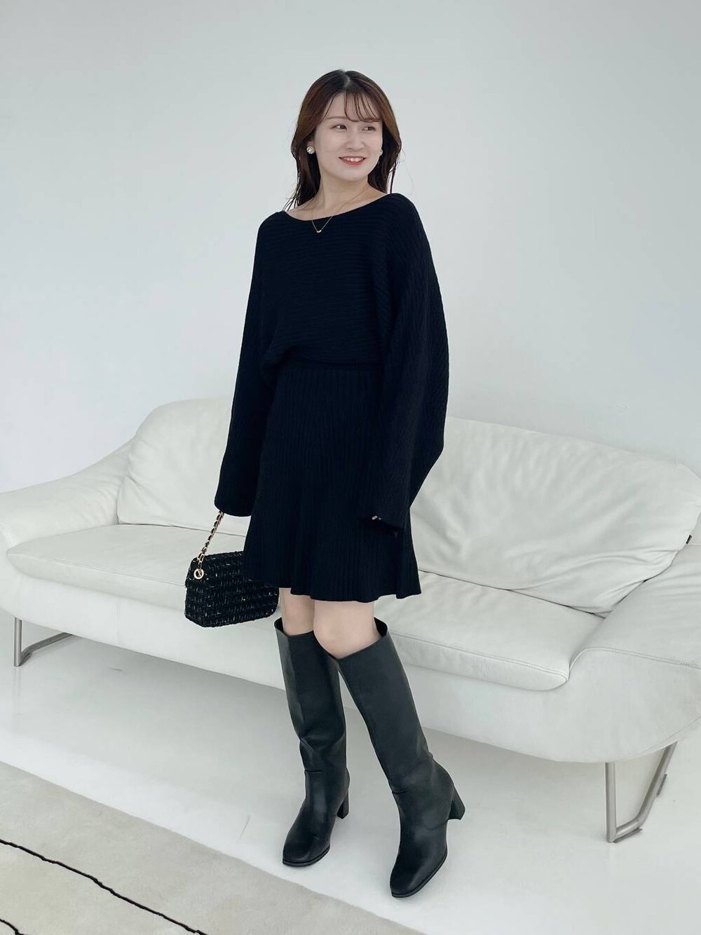 その他のショルダーバッグ、ブラック系のブーツ、ブラック系のワンピースを着用したレディースの秋コーディネートの1枚目の写真