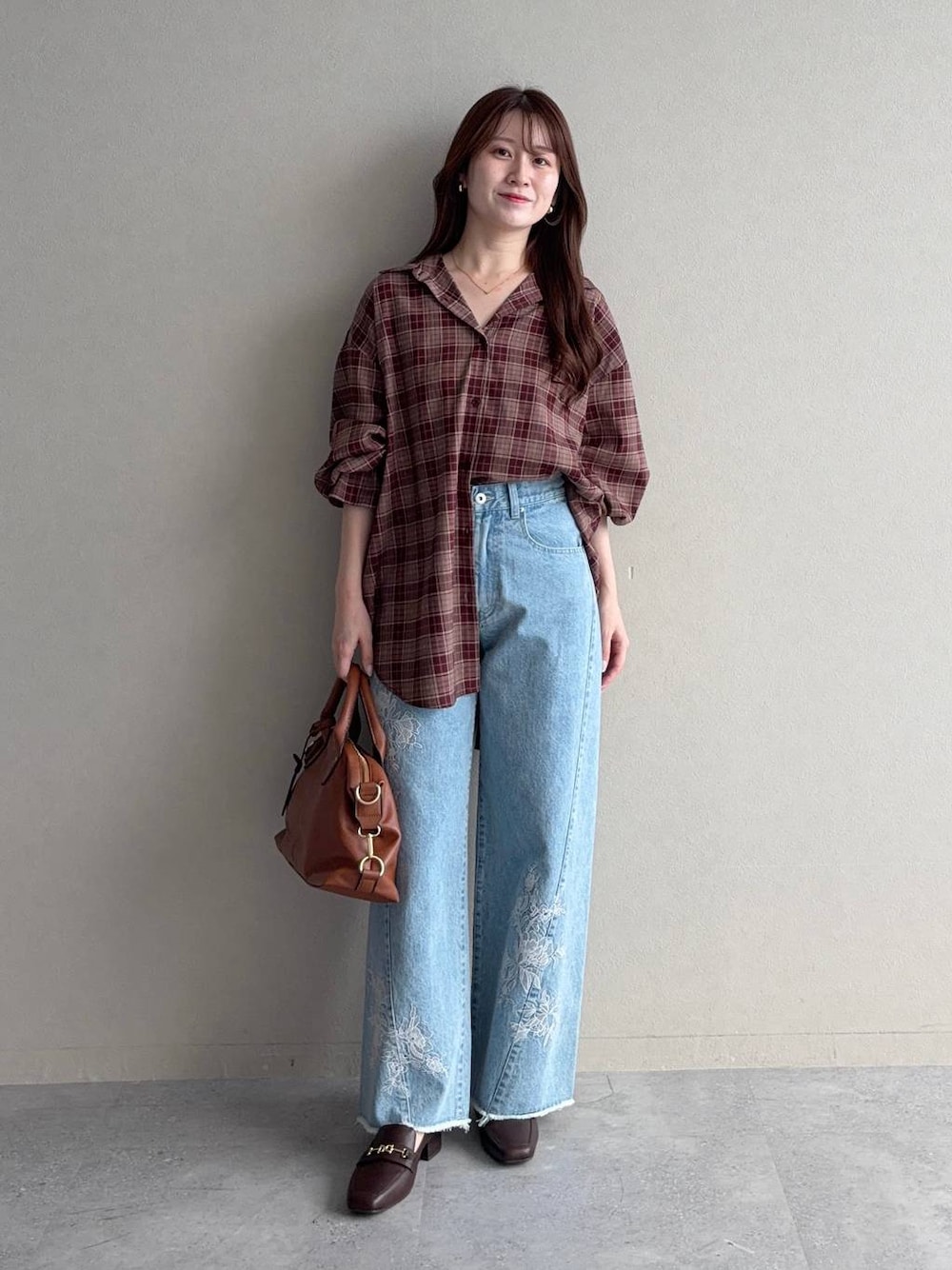 ブラウン系のローファー、レッド系のシャツ/ブラウス、ブルー系のデニムパンツを着用したレディースの秋コーディネートの1枚目の写真