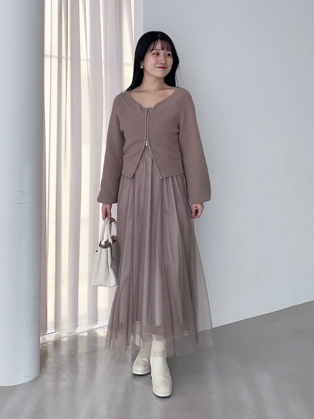 ホワイト系のブーツ、ホワイト系のショルダーバッグ、ブラウン系のワンピースを着用したレディースの春コーディネートの1枚目の写真