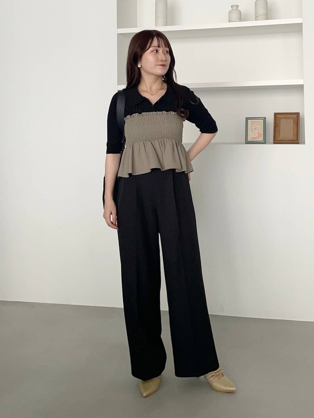 ブラック系のスラックス、ゴールド系のパンプス、グリーン系のスカートを着用したレディースの夏コーディネートの1枚目の写真