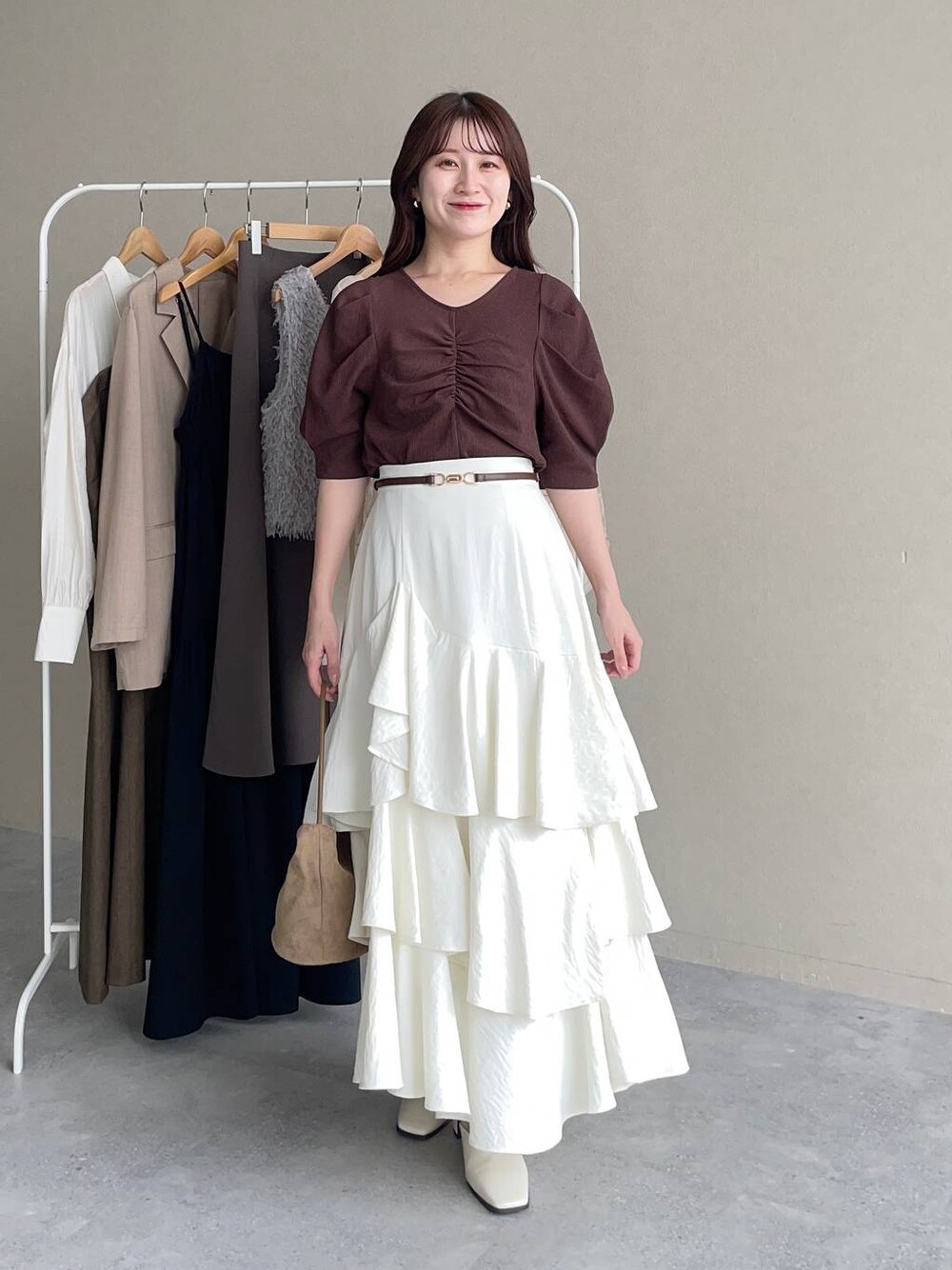 ブラウン系のTシャツ/カットソー、ホワイト系のスカート、ホワイト系のスリッポンを着用したレディースの夏コーディネートの1枚目の写真