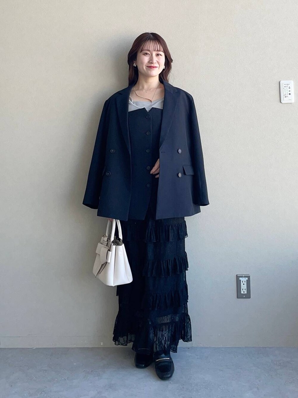 ホワイト系のショルダーバッグ、ブルー系のテーラードジャケット、ブルー系のその他トップスを着用したレディースの冬コーディネートの1枚目の写真