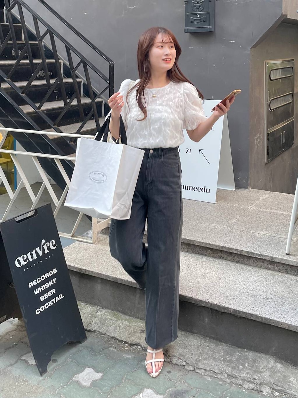 ホワイト系のシャツ/ブラウス、ホワイト系のサンダル、ブラック系のデニムパンツを着用したレディースの夏コーディネートの1枚目の写真