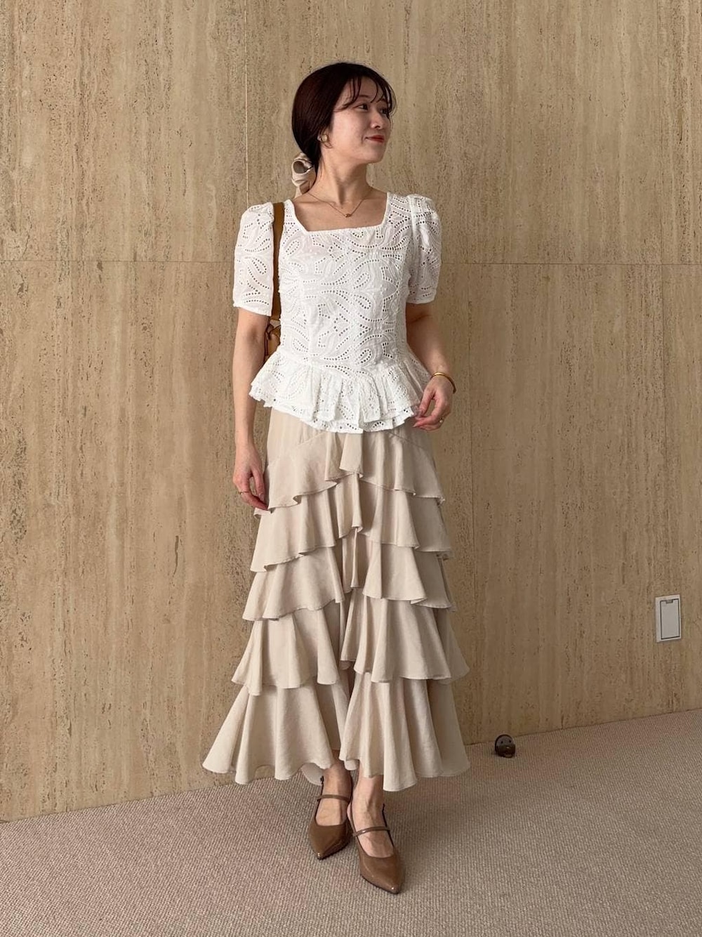 ブラウン系のサンダル、ホワイト系のシャツ/ブラウス、ベージュ系のスカートを着用したレディースの春コーディネートの1枚目の写真