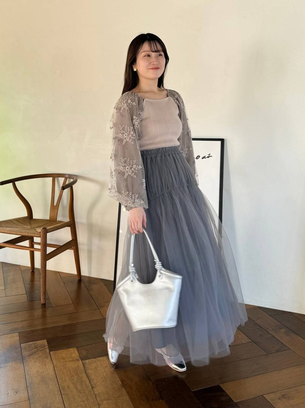 シルバー系のバレエシューズ、グレー系のスカート、ブラウン系のニット/セーターを着用したレディースの春コーディネートの1枚目の写真