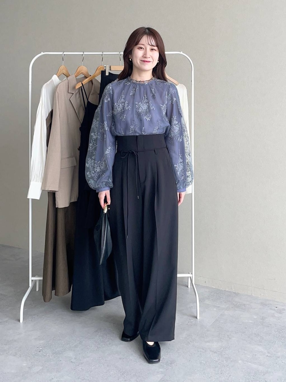 ブラック系のハンドバッグ、ブルー系のシャツ/ブラウス、ブラック系のその他パンツを着用したレディースの秋コーディネートの1枚目の写真