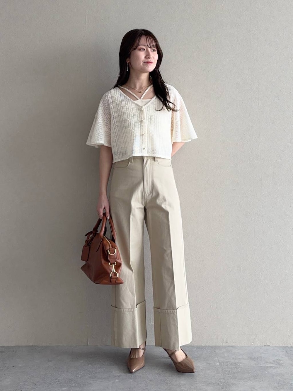 ホワイト系のカーディガン/ボレロ、ブラウン系のボストンバッグ、ブラウン系のサンダルを着用したレディースの春コーディネートの1枚目の写真