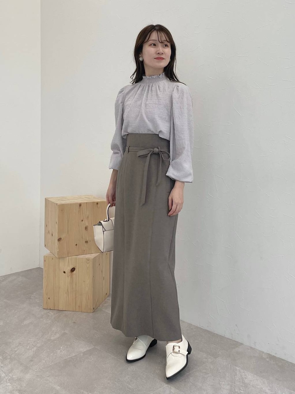 ブラウン系のスカート、ホワイト系のその他シューズ、ホワイト系のハンドバッグを着用したレディースの秋コーディネートの1枚目の写真