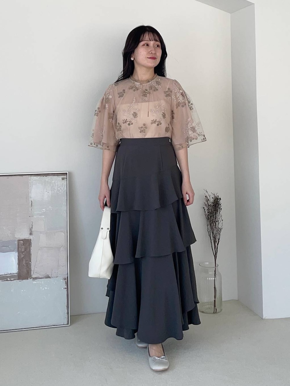 グレー系のスカート、シルバー系のバレエシューズ、ピンク系のシャツ/ブラウスを着用したレディースの春コーディネートの1枚目の写真