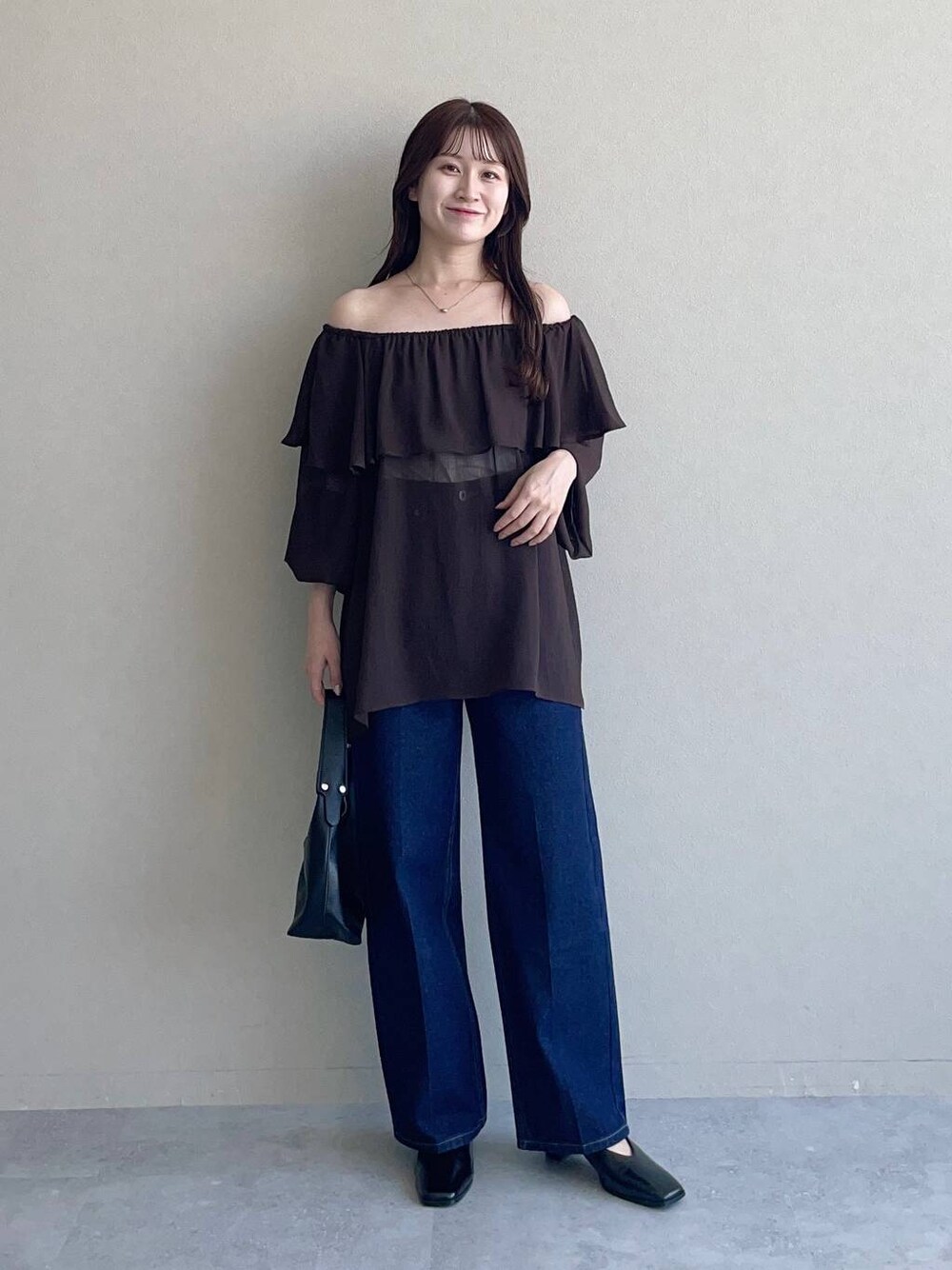 ブラック系のショルダーバッグ、ブラウン系のシャツ/ブラウス、ブルー系のデニムパンツを着用したレディースの夏コーディネートの1枚目の写真