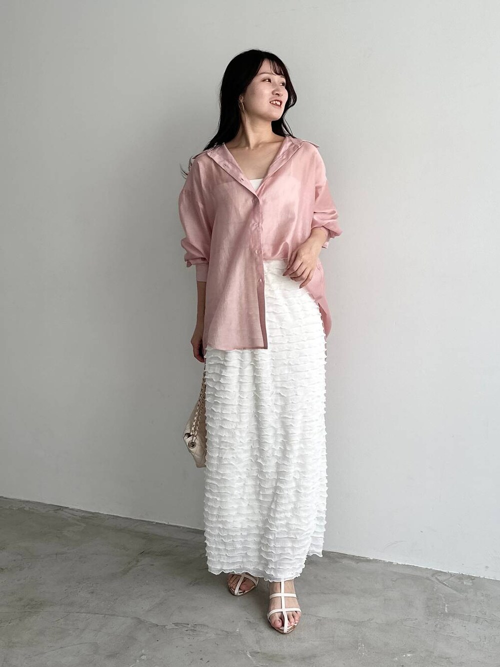 ホワイト系のスカート、ピンク系のシャツ/ブラウス、ホワイト系のショルダーバッグを着用したレディースの夏コーディネートの1枚目の写真