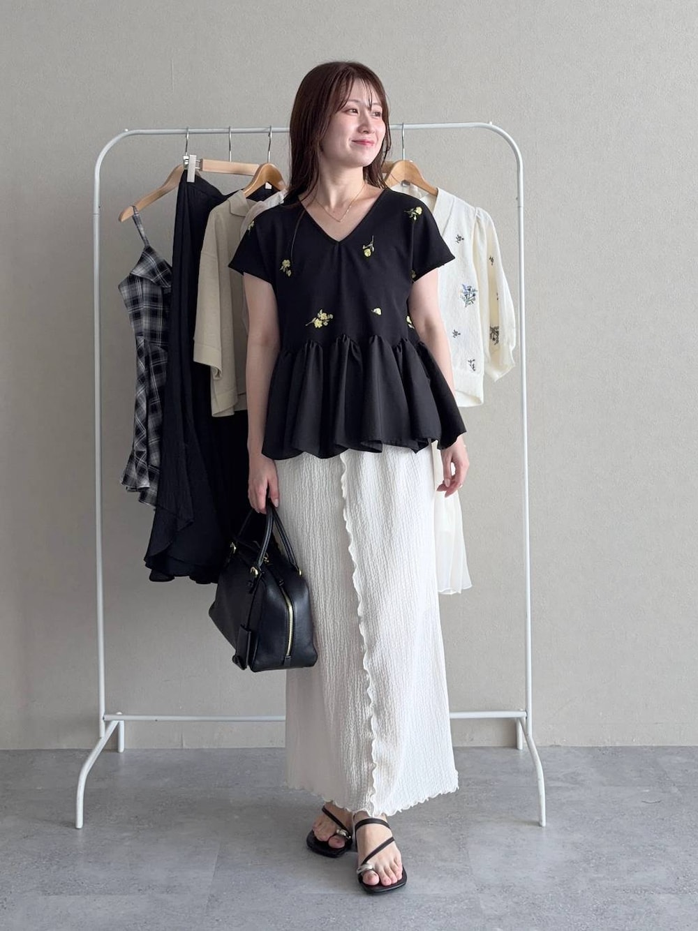 その他のTシャツ/カットソー、ホワイト系のスカート、ブラック系のハンドバッグを着用したレディースの夏コーディネートの1枚目の写真