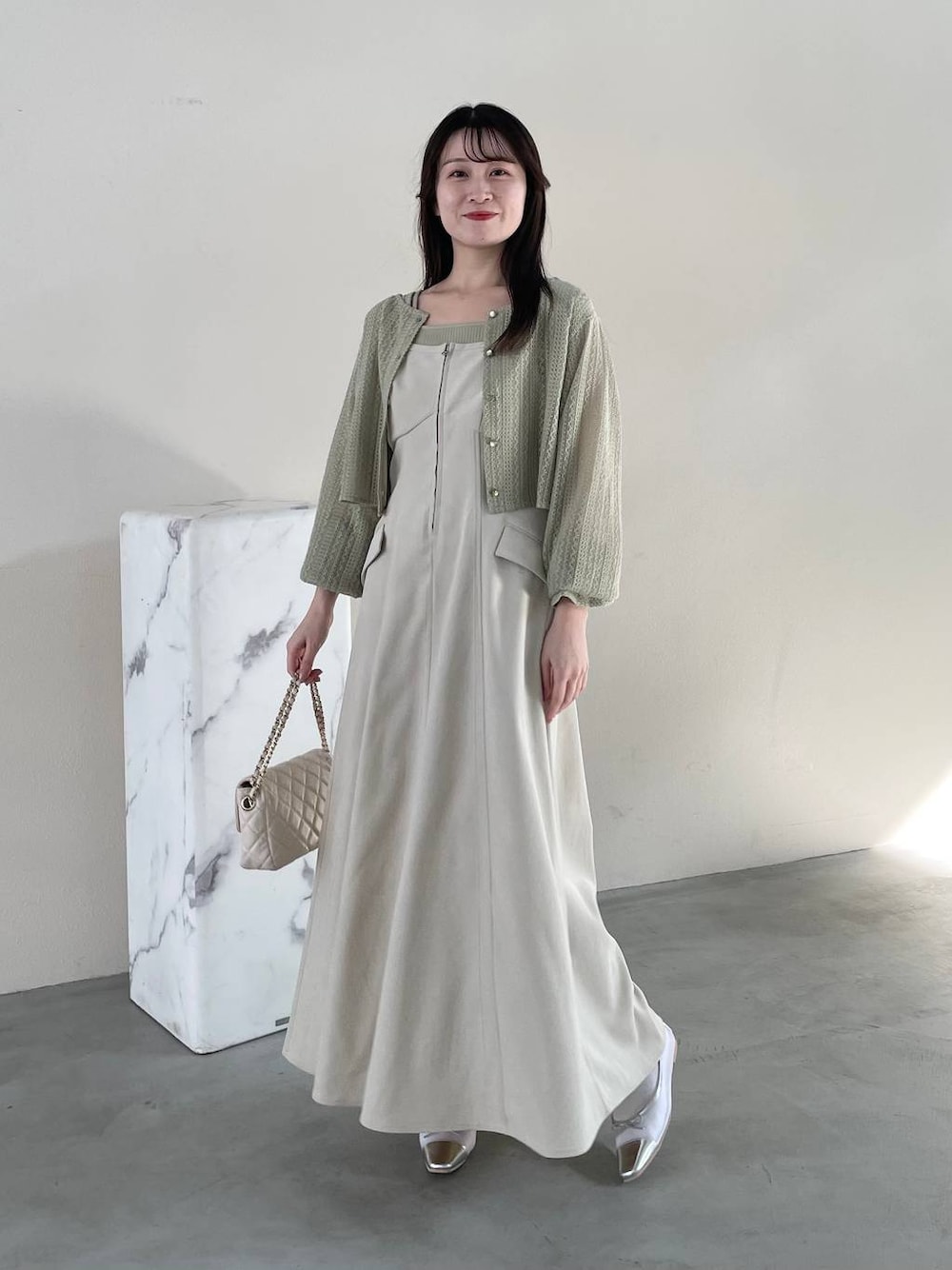 ホワイト系のワンピース、ホワイト系のショルダーバッグ、グリーン系のTシャツ/カットソーを着用したレディースの春コーディネートの1枚目の写真