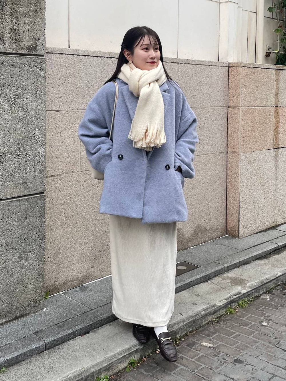 ホワイト系のスカート、グレー系のテーラードジャケット、ホワイト系のマフラーを着用したレディースの冬コーディネートの1枚目の写真