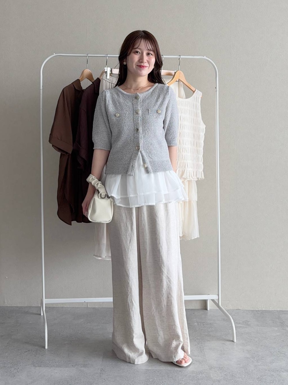 ブルー系のニット/セーター、グレー系のカーディガン/ボレロ、ベージュ系のその他パンツを着用したレディースの夏コーディネートの1枚目の写真