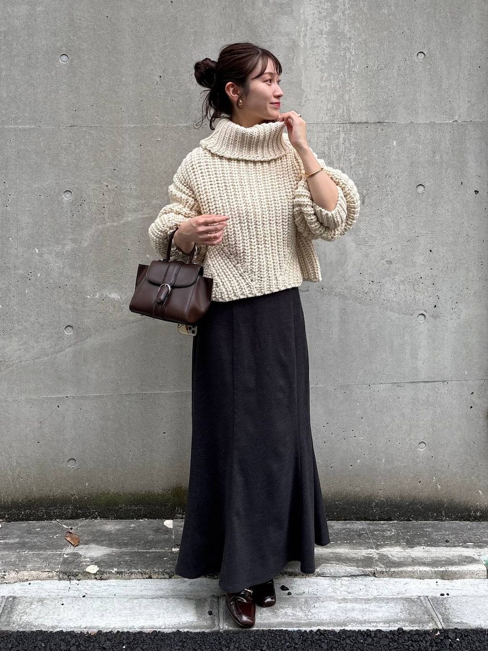 ホワイト系のニット/セーター、グレー系のスカートを着用したレディースの秋コーディネートの1枚目の写真