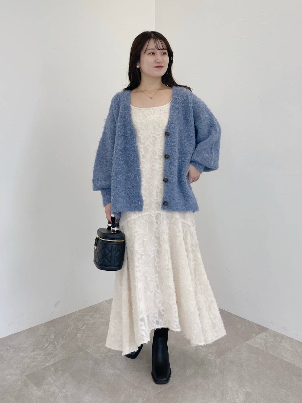 ブルー系のカーディガン/ボレロ、ブラック系のショルダーバッグ、ホワイト系のワンピースを着用したレディースの秋コーディネートの1枚目の写真