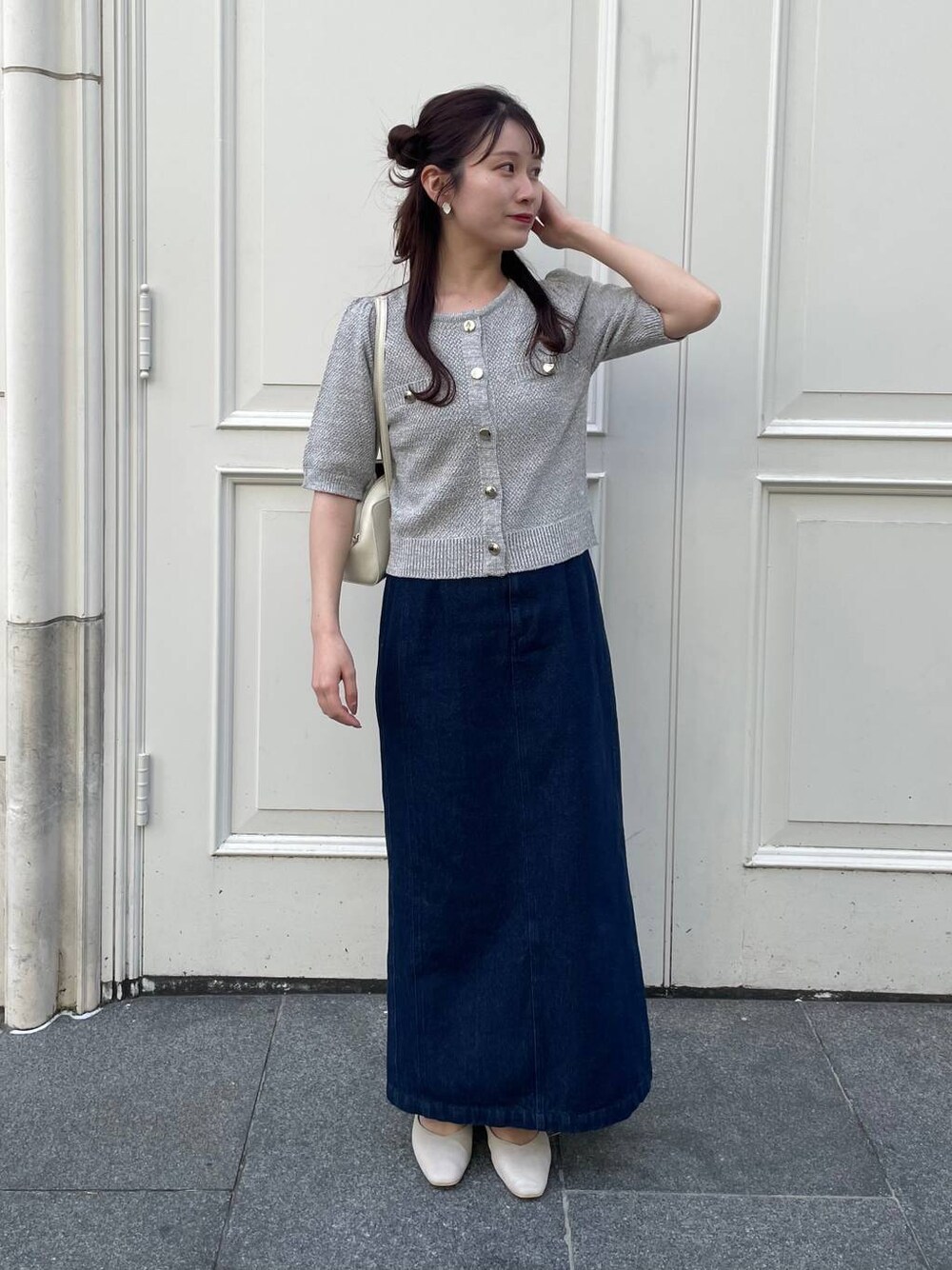 ベージュ系のパンプス、ブルー系のスカート、グレー系のカーディガン/ボレロを着用したレディースの春コーディネートの1枚目の写真