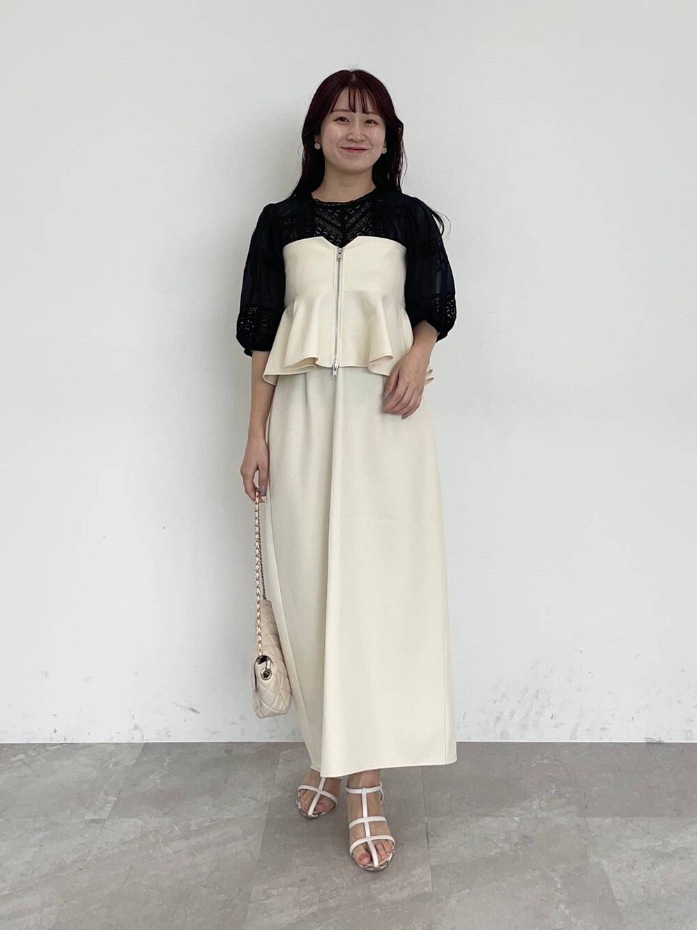 ホワイト系のスカート、ブラック系のシャツ/ブラウス、ホワイト系のショルダーバッグを着用したレディースの夏コーディネートの1枚目の写真