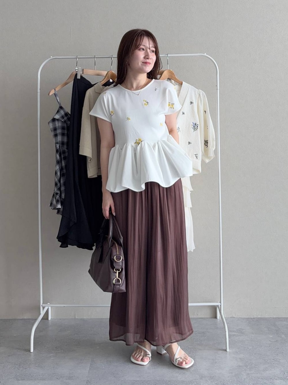 ホワイト系のTシャツ/カットソー、ブラウン系のその他パンツ、ブラウン系のボストンバッグを着用したレディースの夏コーディネートの1枚目の写真