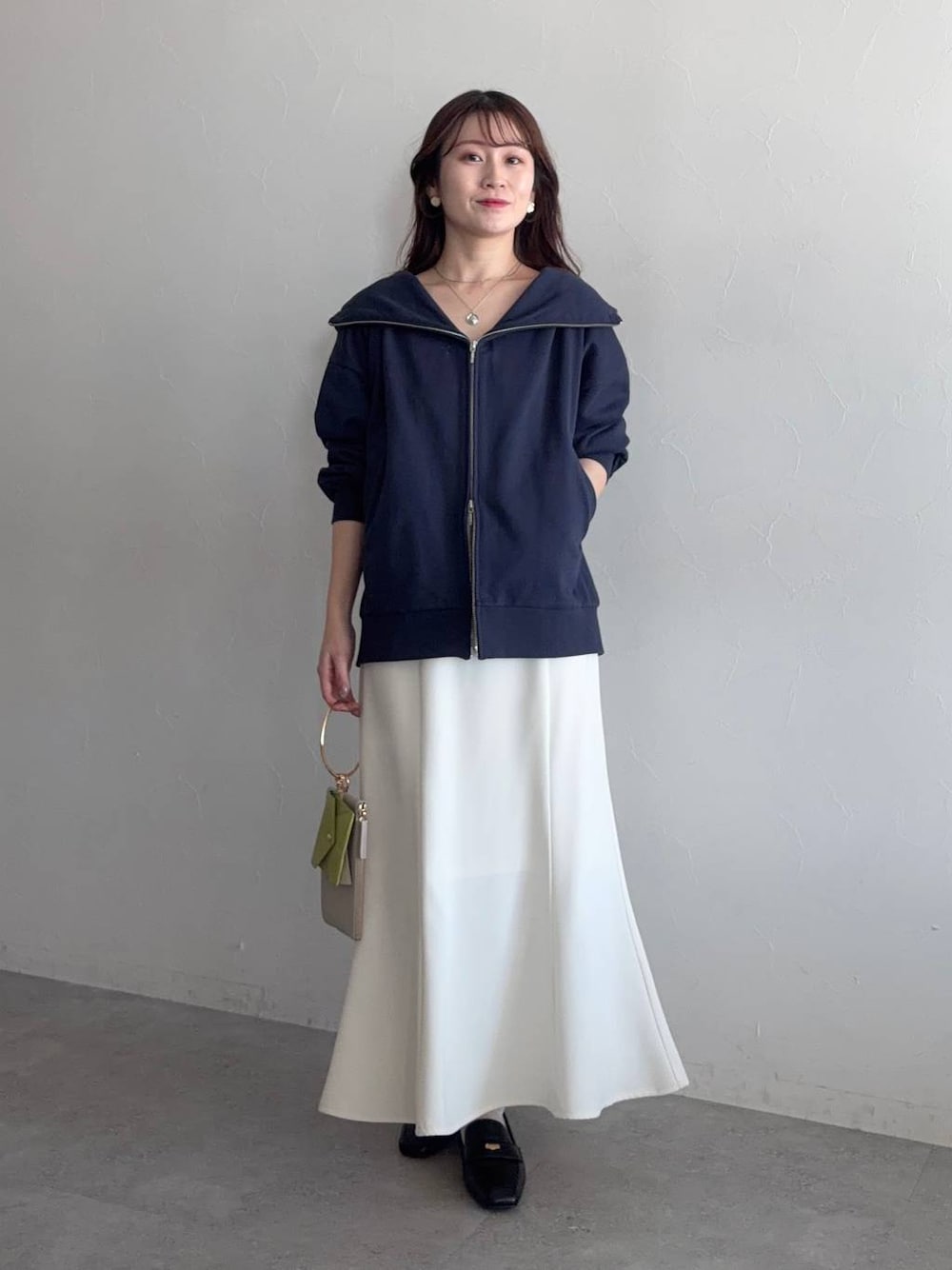 ブラック系のローファー、ブルー系のパーカー、ホワイト系のスカートを着用したレディースの冬コーディネートの1枚目の写真