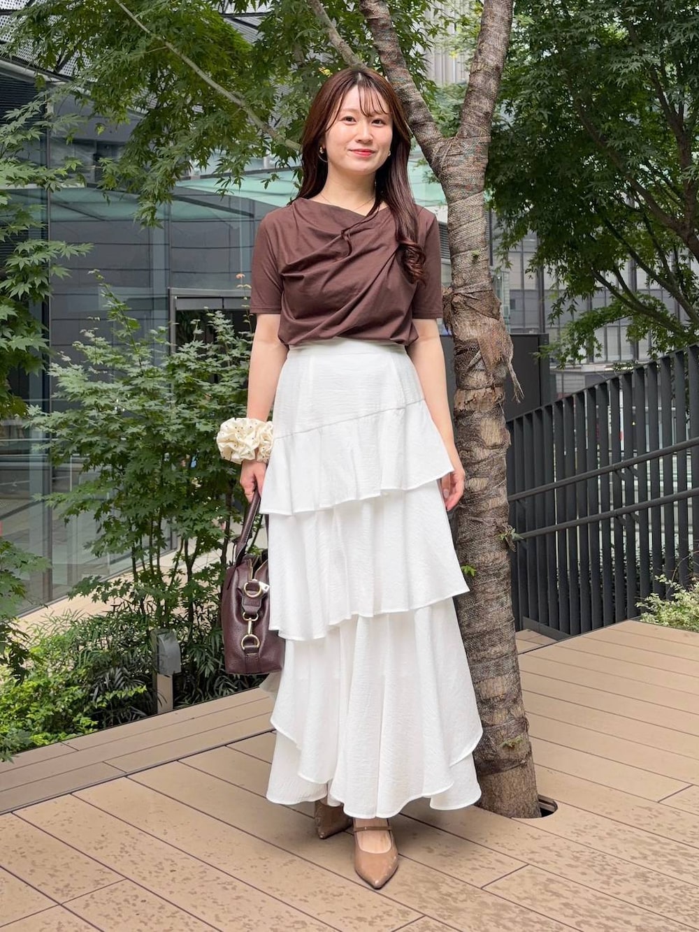 ブラウン系のTシャツ/カットソー、ホワイト系のスカート、ブラウン系のボストンバッグを着用したレディースの夏コーディネートの1枚目の写真