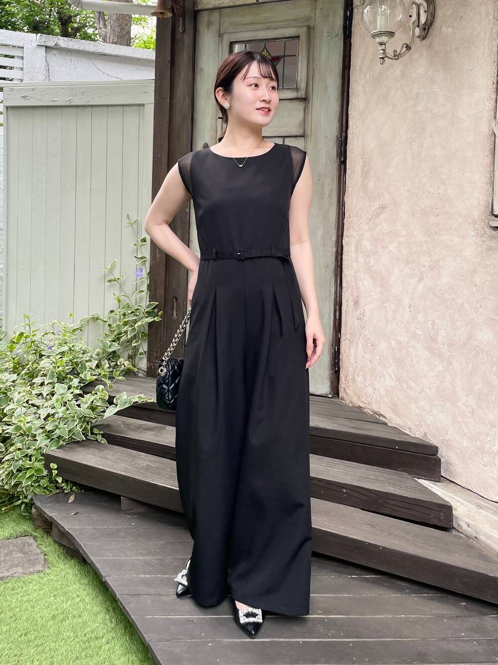 ブラック系のパンプス、ブラック系のショルダーバッグ、ブラック系のつなぎ/オールインワンを着用したレディースの夏コーディネートの1枚目の写真