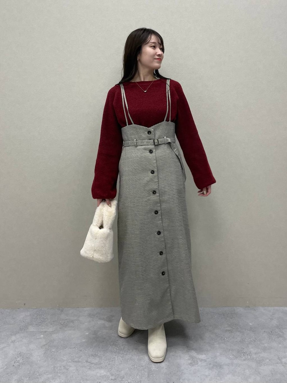 レッド系のニット/セーター、ホワイト系のブーツ、その他のスカートを着用したレディースの秋コーディネートの1枚目の写真