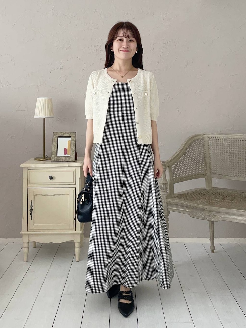 ブラック系のパンプス、ブラック系のショルダーバッグ、ホワイト系のカーディガン/ボレロを着用したレディースの夏コーディネートの1枚目の写真