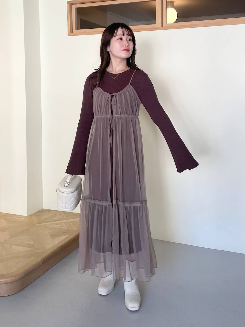 ホワイト系のブーツ、ホワイト系のショルダーバッグ、ブラウン系のワンピースを着用したレディースの冬コーディネートの1枚目の写真