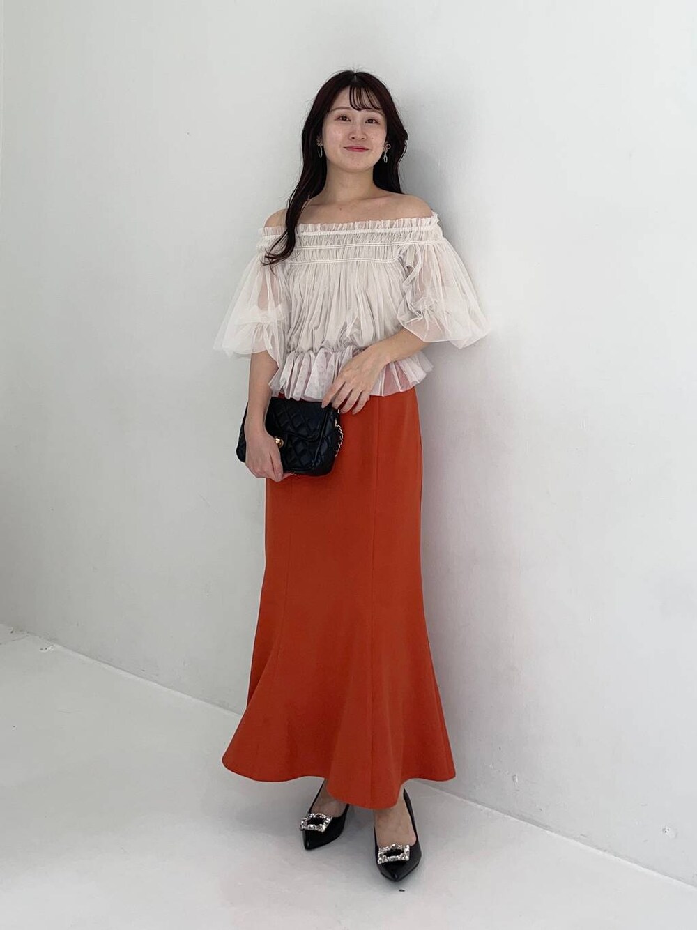 ブラック系のパンプス、ホワイト系のシャツ/ブラウス、ブラック系のショルダーバッグを着用したレディースの夏コーディネートの1枚目の写真