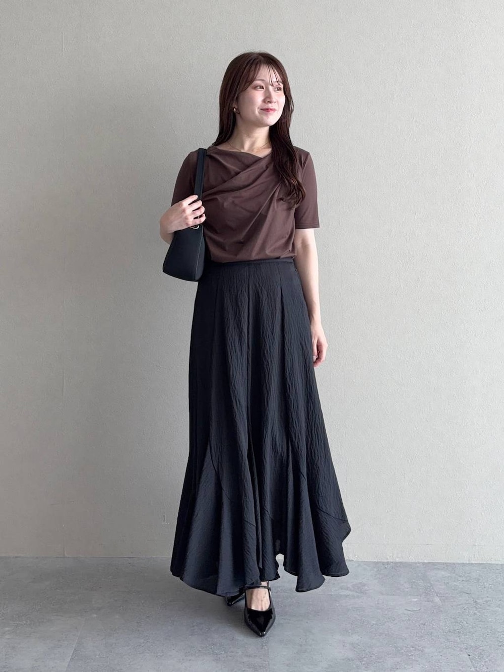 ブラウン系のTシャツ/カットソー、ブラック系のサンダル、ブラック系のスカートを着用したレディースの夏コーディネートの1枚目の写真