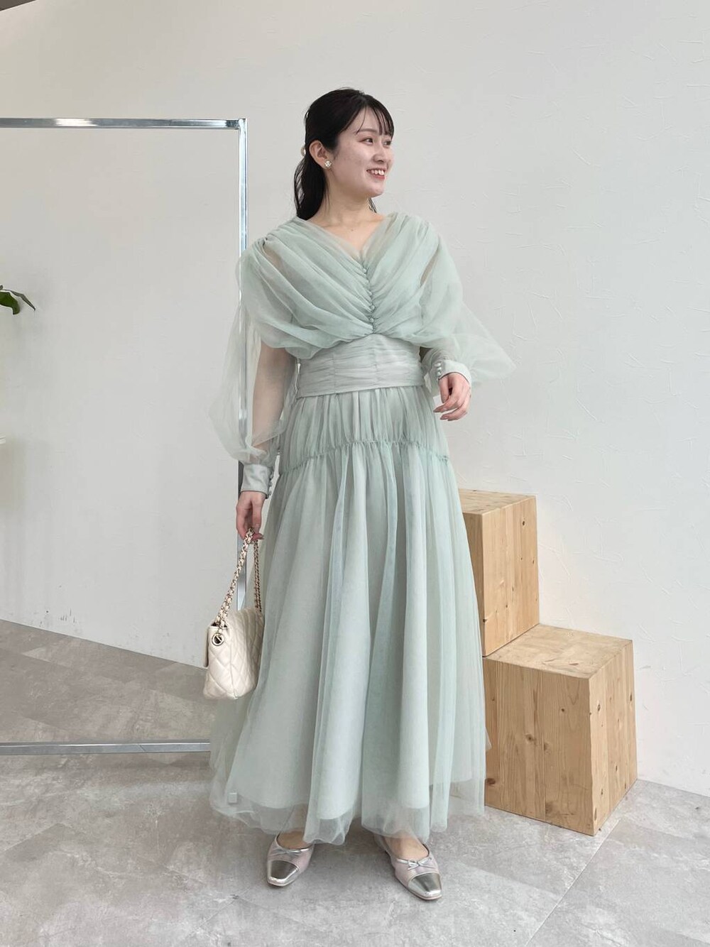 シルバー系のバレエシューズ、グリーン系のTシャツ/カットソー、ホワイト系のショルダーバッグを着用したレディースの春コーディネートの1枚目の写真