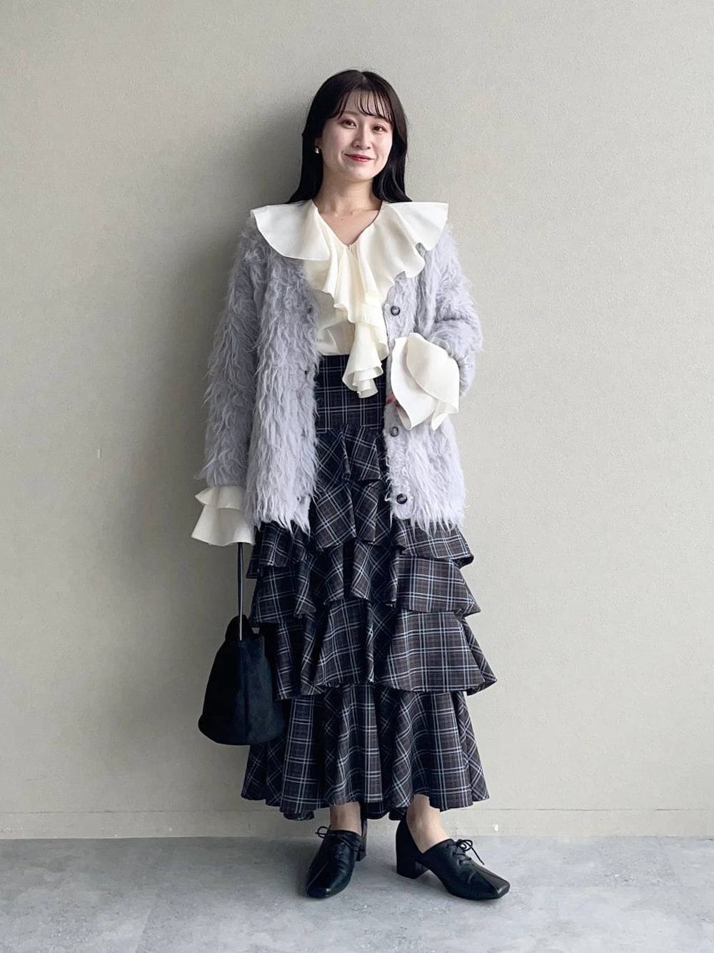 ホワイト系のシャツ/ブラウス、グレー系のカーディガン/ボレロ、ブラウン系のスカートを着用したレディースの秋コーディネートの1枚目の写真