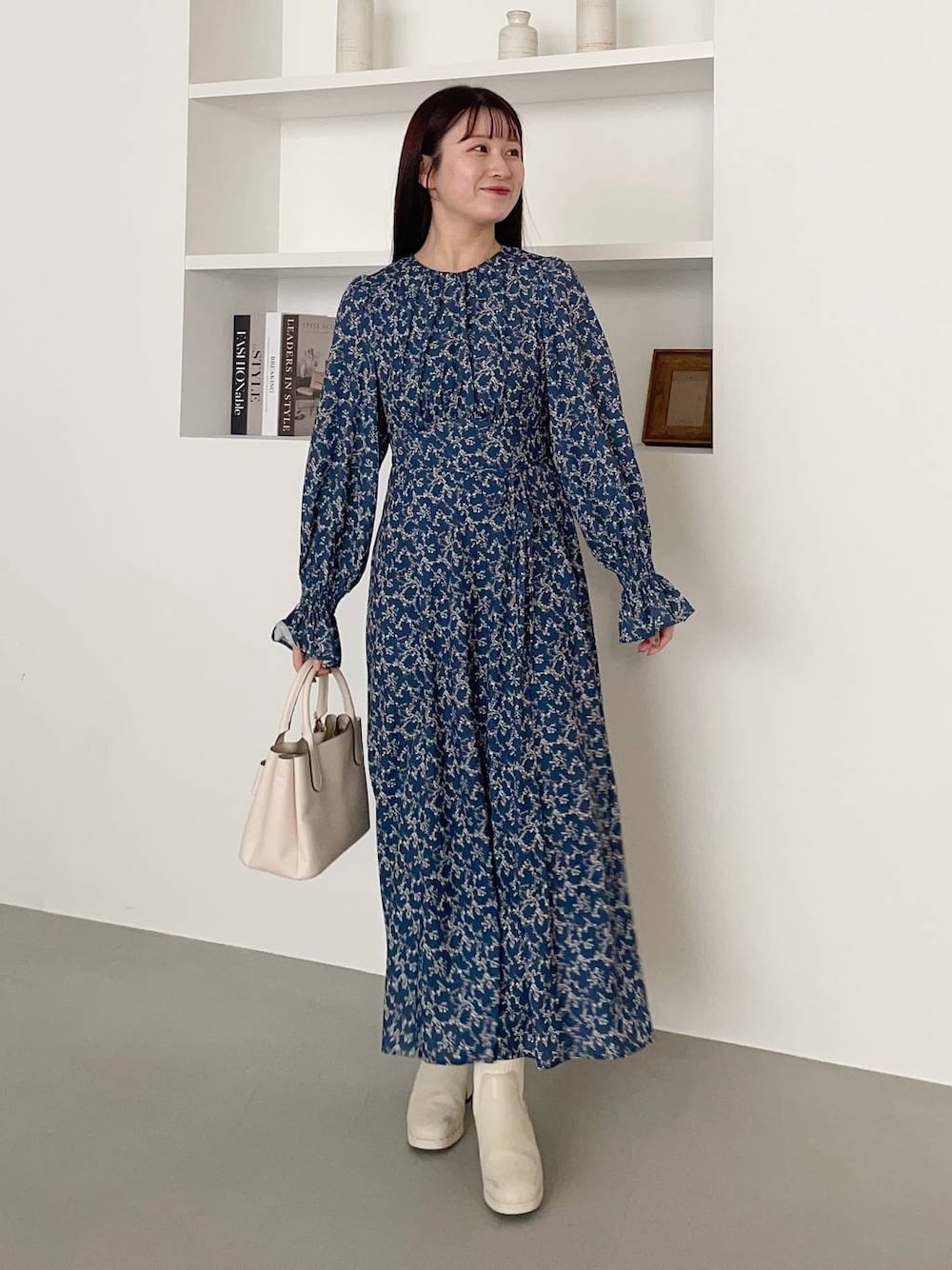 ホワイト系のブーツ、ホワイト系のショルダーバッグ、ブルー系のワンピースを着用したレディースの春コーディネートの1枚目の写真