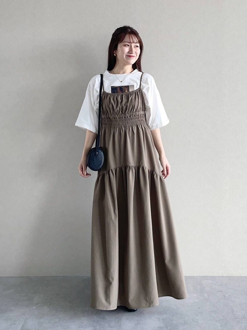 ホワイト系のTシャツ/カットソー、ブラック系のショルダーバッグ、ブラウン系のワンピースを着用したレディースの秋コーディネートの1枚目の写真