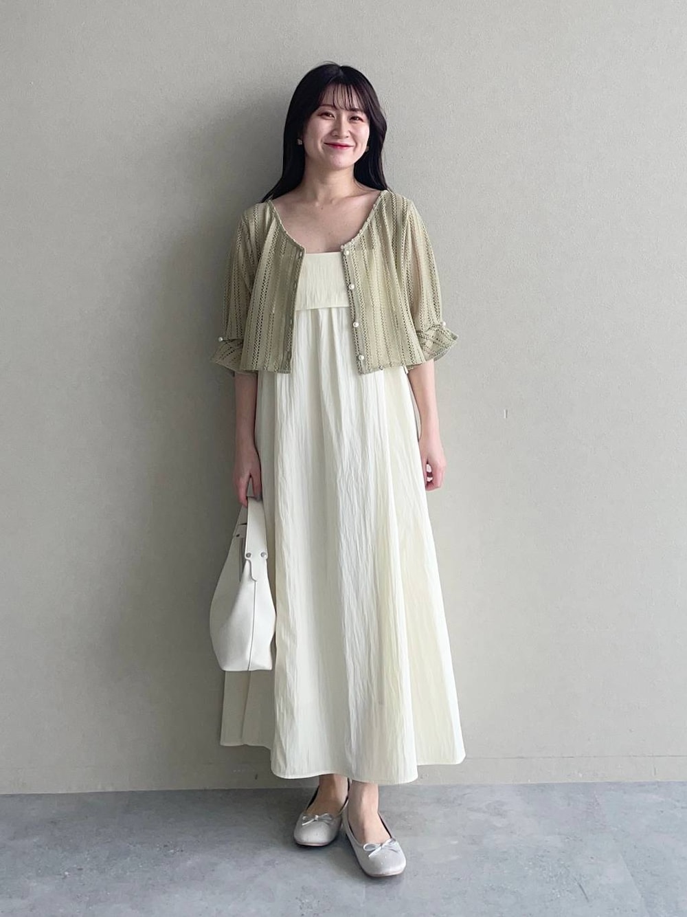 グリーン系のカーディガン/ボレロ、ホワイト系のショルダーバッグ、ホワイト系のワンピースを着用したレディースの夏コーディネートの1枚目の写真