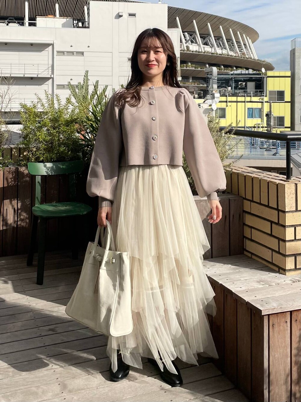 ベージュ系のカーディガン/ボレロ、ホワイト系のトートバッグ、ホワイト系のスカートを着用したレディースの冬コーディネートの1枚目の写真