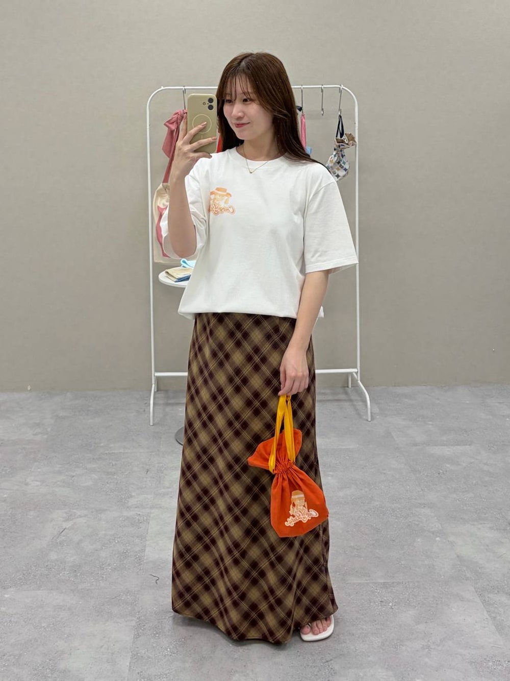 ホワイト系のTシャツ/カットソー、レッド系のスカート、ホワイト系のポーチを着用したレディースの夏コーディネートの1枚目の写真