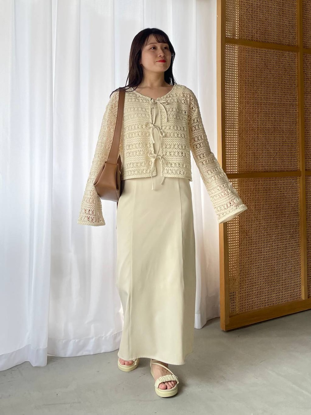 ホワイト系のドレス、ホワイト系のサンダル、ホワイト系のカーディガン/ボレロを着用したレディースの春コーディネートの1枚目の写真