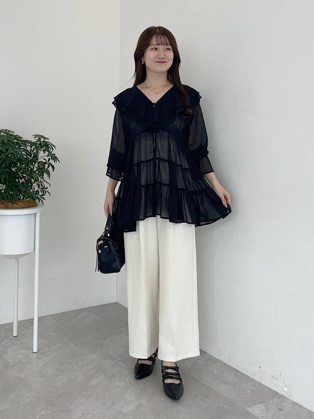 ブラック系のパンプス、ブラック系のショルダーバッグ、ブラック系のシャツ/ブラウスを着用したレディースの夏コーディネートの1枚目の写真