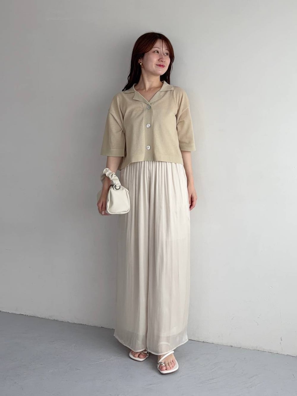 ホワイト系のその他パンツ、ベージュ系のニット/セーター、ホワイト系のショルダーバッグを着用したレディースの夏コーディネートの1枚目の写真