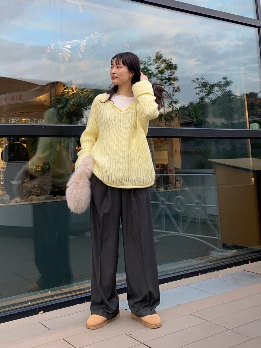 ベージュ系のハンドバッグ、ブラウン系のブーツ、グレー系のその他パンツを着用したレディースの冬コーディネートの1枚目の写真